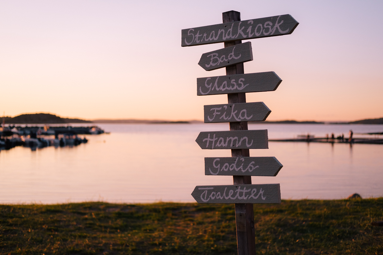 Sign pointing to ice cream, beach, harbor, toilets